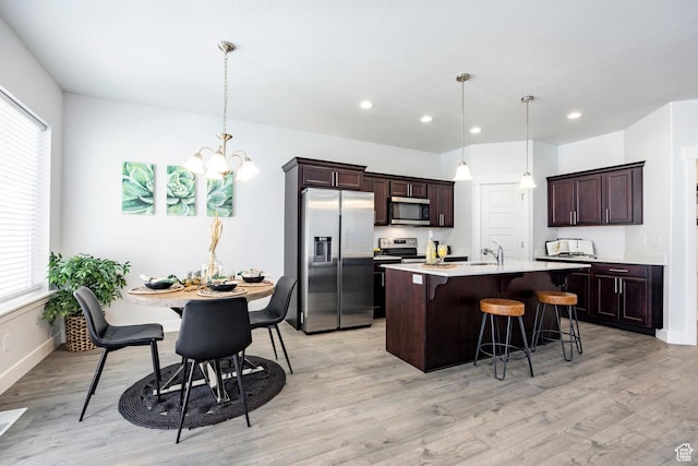 1629 N 3860 W, Lehi, UT 84043 - kitchen with an inviting chandelier, a sink, a kitchen bar, dark brown cabinets, and stainless steel appliances
