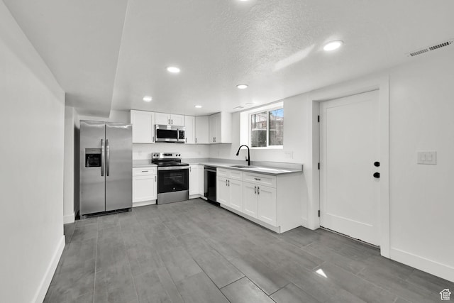 1289 E 31st St S, Ogden, UT 84403 - kitchen with visible vents, white cabinets, appliances with stainless steel finishes, light countertops, and a sink