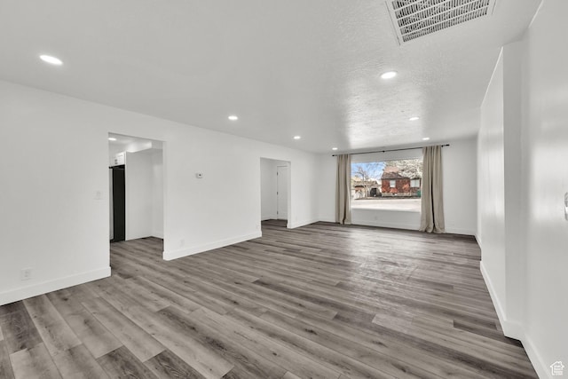 1289 E 31st St S, Ogden, UT 84403 - unfurnished living room featuring visible vents, baseboards, a textured ceiling, recessed lighting, and wood finished floors
