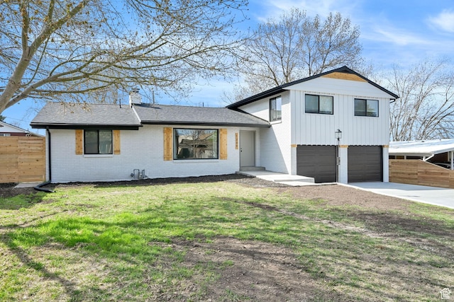 tri-level home with brick siding, an attached garage, fence, and driveway