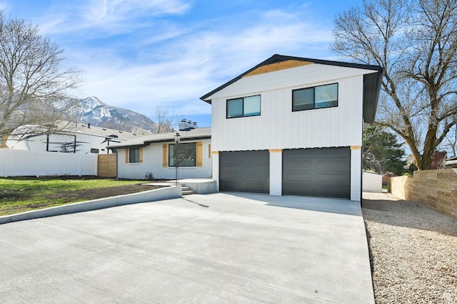 1289 E 31st St S, Ogden, UT 84403 - view of front of house featuring a mountain view, driveway, an attached garage, brick siding, and fence
