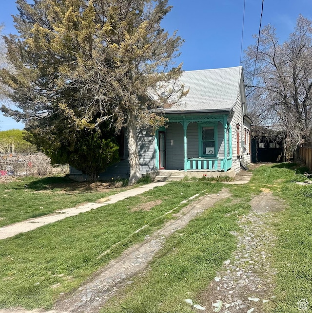 view of front of home featuring a front yard, a porch, and fence