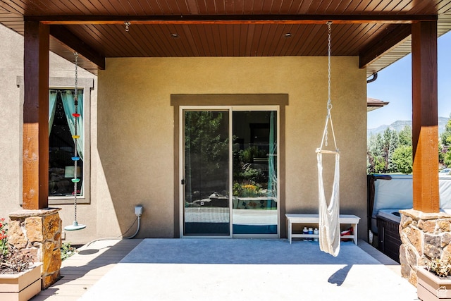 entrance to property with a patio area and stucco siding