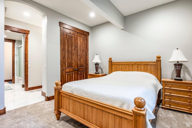 bedroom featuring arched walkways, light colored carpet, baseboards, and recessed lighting