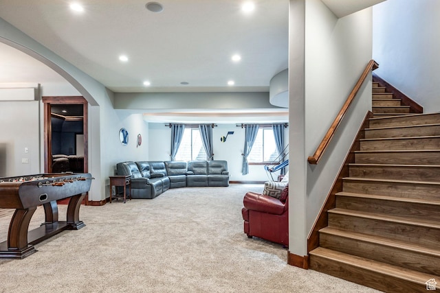 living area featuring baseboards, recessed lighting, carpet floors, stairs, and arched walkways