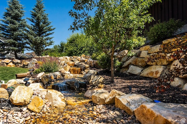 view of yard with a small pond and fence