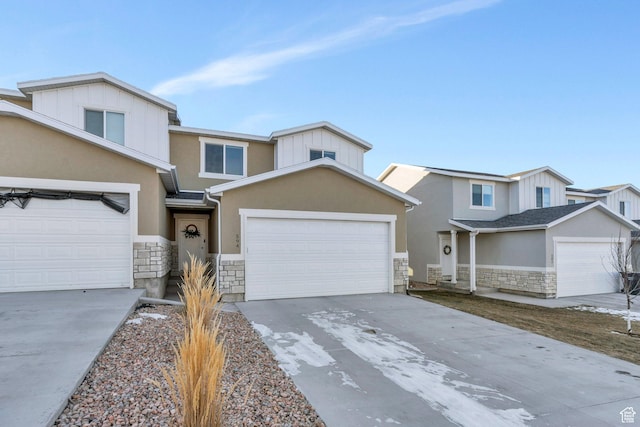 view of front of home with stucco siding, stone siding, a garage, and concrete driveway