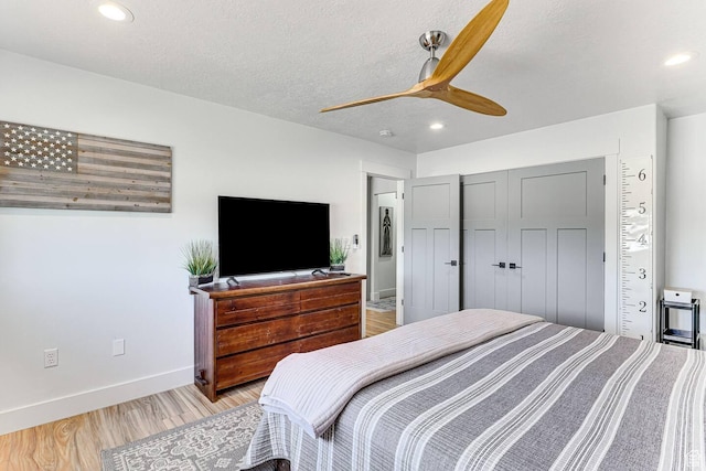 bedroom with a textured ceiling, light wood finished floors, baseboards, and recessed lighting