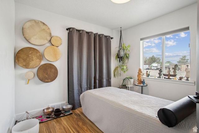 bedroom featuring wood finished floors and visible vents