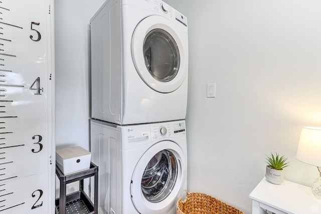 laundry area featuring stacked washer / dryer and laundry area
