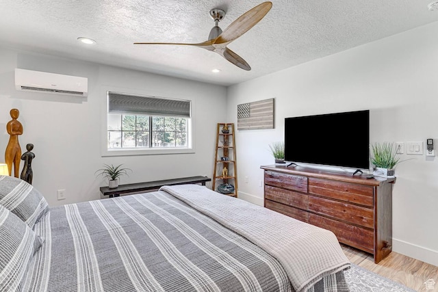 bedroom featuring light wood-type flooring, baseboards, a wall mounted air conditioner, recessed lighting, and ceiling fan