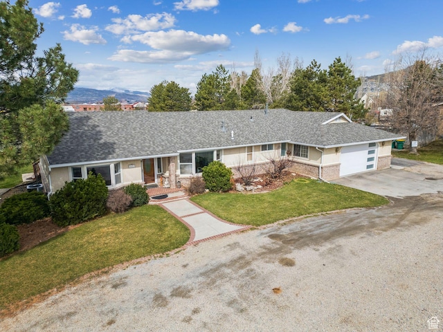 ranch-style house featuring a shingled roof, an attached garage, concrete driveway, stucco siding, and a front lawn