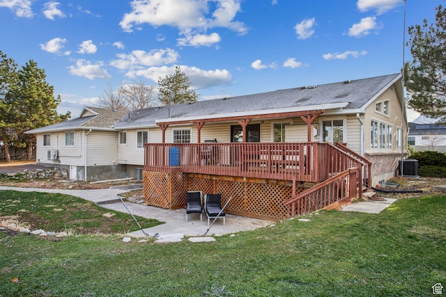 rear view of property with central AC, a shingled roof, a yard, a patio, and a wooden deck