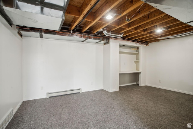 finished below grade area featuring a baseboard heating unit, baseboards, visible vents, and carpet floors