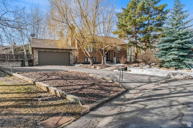 745 Quaking Aspen Ct, Park City, UT 84060 - view of front facade featuring a chimney, aphalt driveway, a garage, and fence