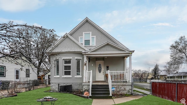view of front of home featuring covered porch, a front yard, fence, and a gate