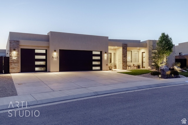 view of front of house with a garage, stucco siding, and concrete driveway