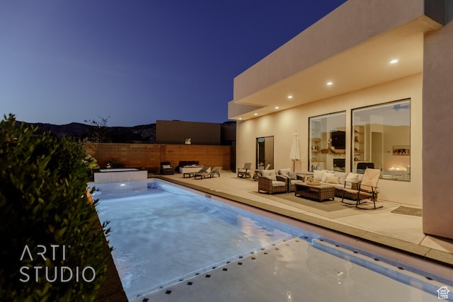 view of pool featuring outdoor lounge area, a patio area, and fence