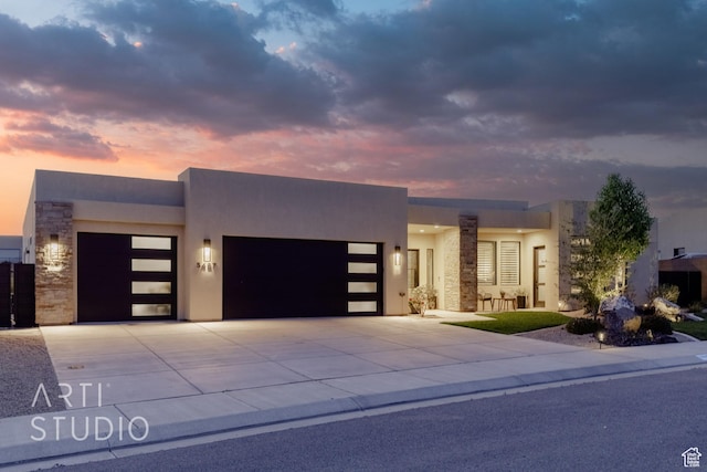 view of front of property featuring concrete driveway, a garage, and stucco siding