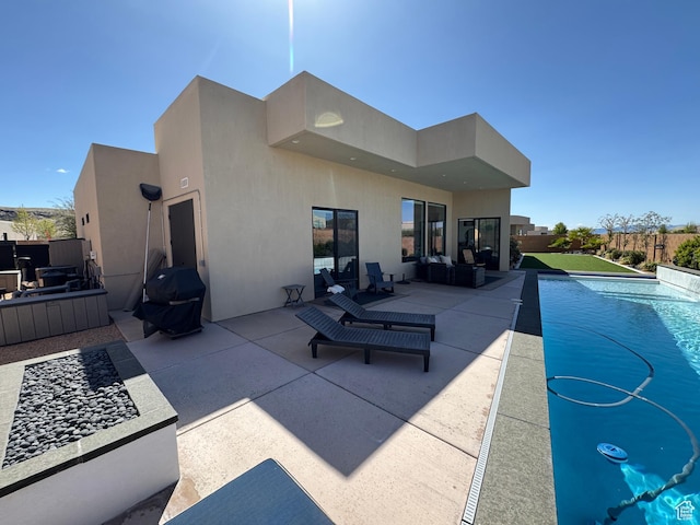 back of property with a fenced in pool, a patio area, stucco siding, and fence