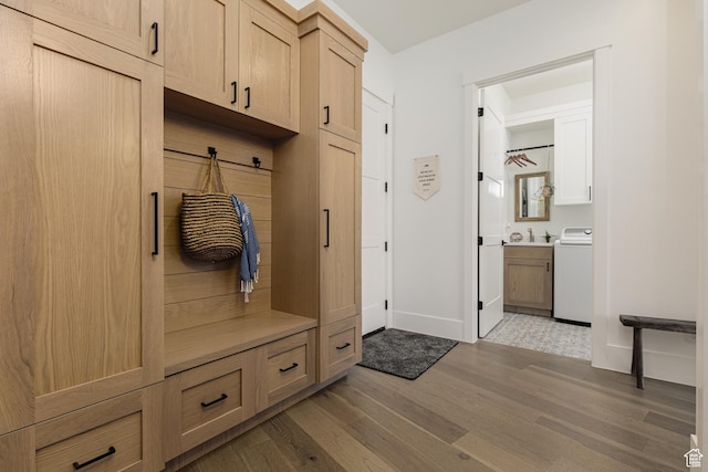 mudroom with wood finished floors, baseboards, and washer / dryer