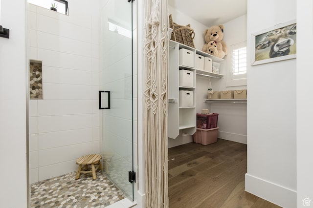 full bathroom with baseboards, a stall shower, and wood finished floors
