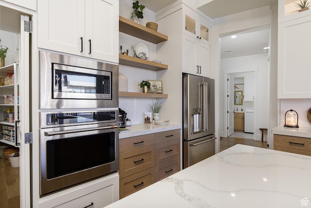kitchen featuring washer / clothes dryer, white cabinets, open shelves, glass insert cabinets, and stainless steel appliances