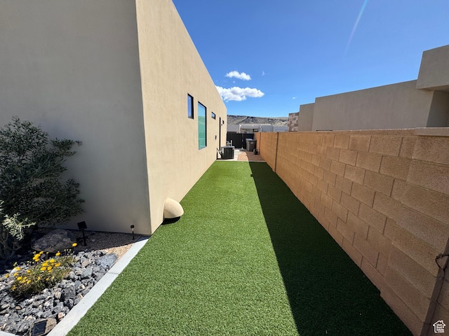 view of yard featuring a fenced backyard and central air condition unit
