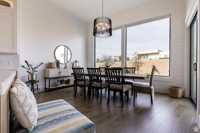dining space with an inviting chandelier and dark wood finished floors
