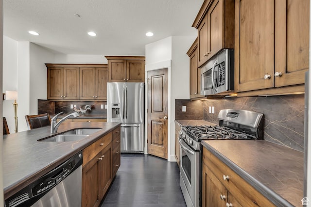 865 W Benjamin Pl, Kamas, UT 84036 - kitchen with brown cabinetry, dark wood-type flooring, appliances with stainless steel finishes, a sink, and dark countertops