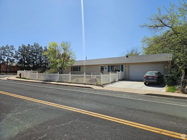view of front facade with a fenced front yard, a garage, and driveway