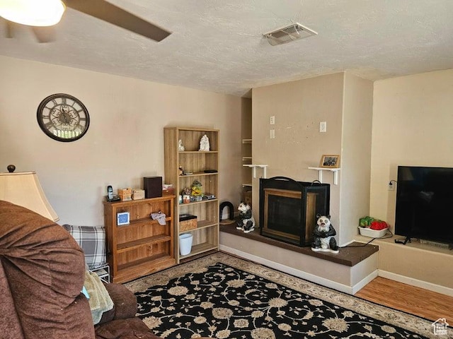 1989 W 1800 N, St George, UT 84770 - living room featuring a fireplace, wood finished floors, and a textured ceiling