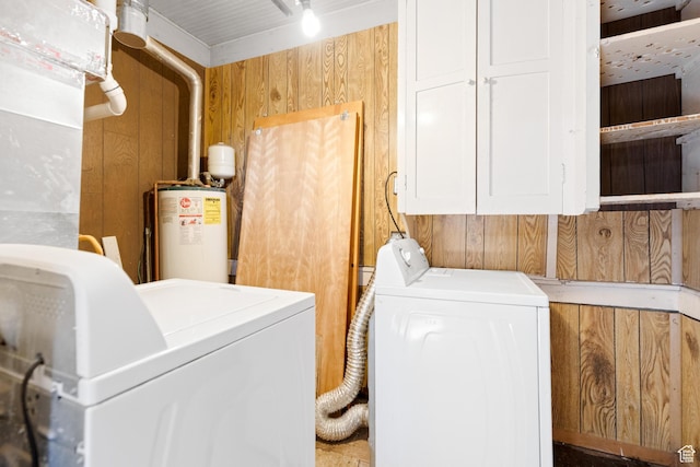 clothes washing area with water heater, washing machine and clothes dryer, and wooden walls