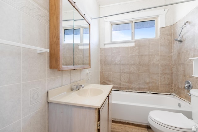 full bath featuring tile walls, toilet, bathtub / shower combination, vanity, and wood finished floors