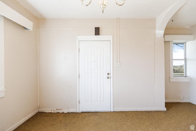 unfurnished room with light carpet and arched walkways
