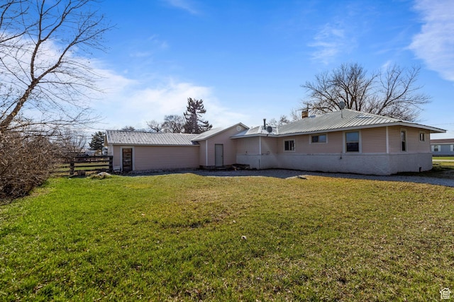back of property featuring a yard, metal roof, and a chimney