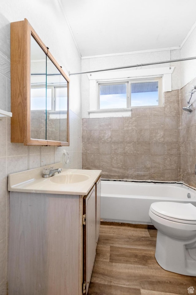 full bathroom with tile walls, toilet, plenty of natural light, and wood finished floors