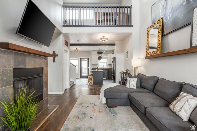 12268 N Ross Creek Dr, Kamas, UT 84036 - living room with dark wood finished floors, baseboards, stairs, a towering ceiling, and a tiled fireplace