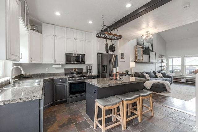 12268 N Ross Creek Dr, Kamas, UT 84036 - kitchen featuring stainless steel appliances, a sink, stone tile flooring, a kitchen island, and a kitchen breakfast bar