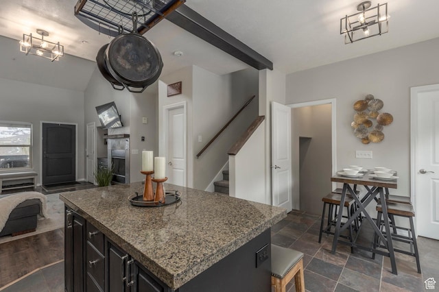 12268 N Ross Creek Dr, Kamas, UT 84036 - kitchen with stone countertops, open floor plan, a kitchen island, dark cabinetry, and vaulted ceiling
