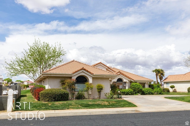 mediterranean / spanish-style home with concrete driveway, stucco siding, a front lawn, and a tile roof