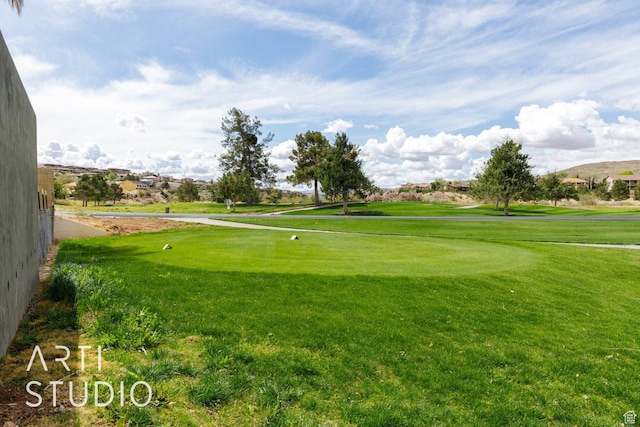 view of property's community with golf course view and a lawn