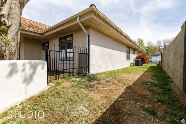view of home's exterior with stucco siding and fence