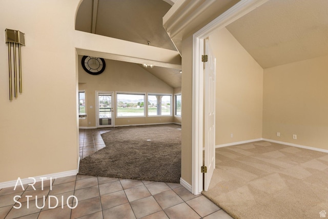 hall featuring high vaulted ceiling, tile patterned flooring, baseboards, and carpet floors