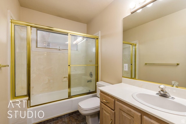 bathroom featuring combined bath / shower with glass door, vanity, and toilet