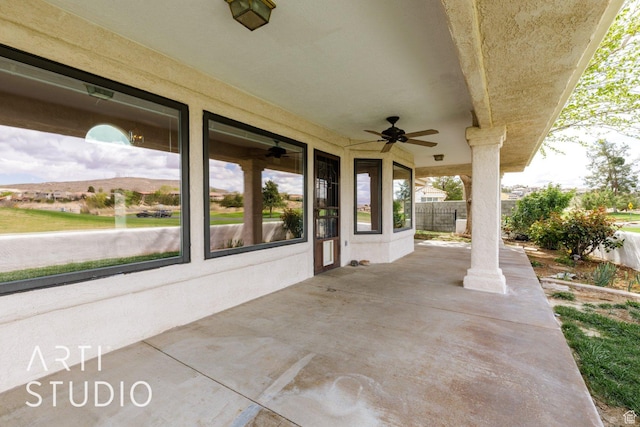 view of patio with fence and a ceiling fan
