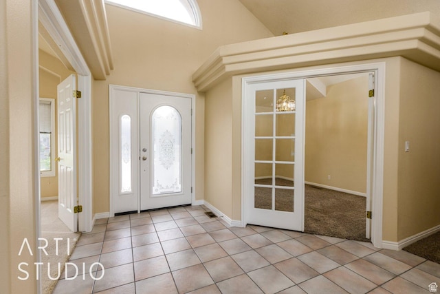 foyer entrance with lofted ceiling, french doors, and light tile patterned flooring