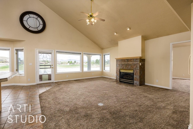 unfurnished living room featuring baseboards, ceiling fan, a fireplace, high vaulted ceiling, and carpet flooring