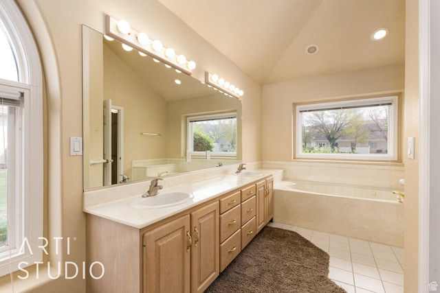 bathroom featuring tile patterned floors, a garden tub, a sink, and vaulted ceiling