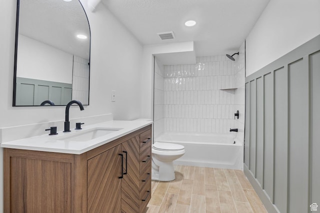 full bathroom featuring visible vents, shower / washtub combination, toilet, vanity, and wood finished floors